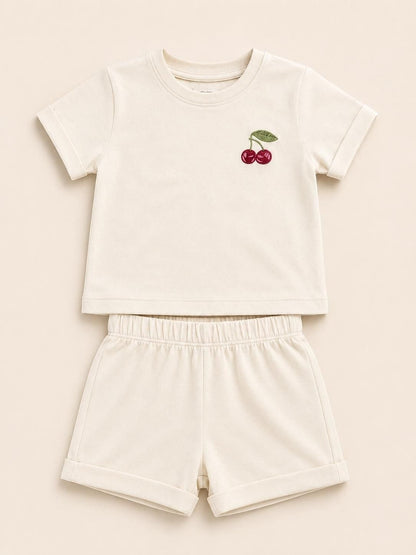 The Nile Luxuries toddler cream short sleeve t-shirt and shorts set with embroidered cherry detail and cuffed hems.
