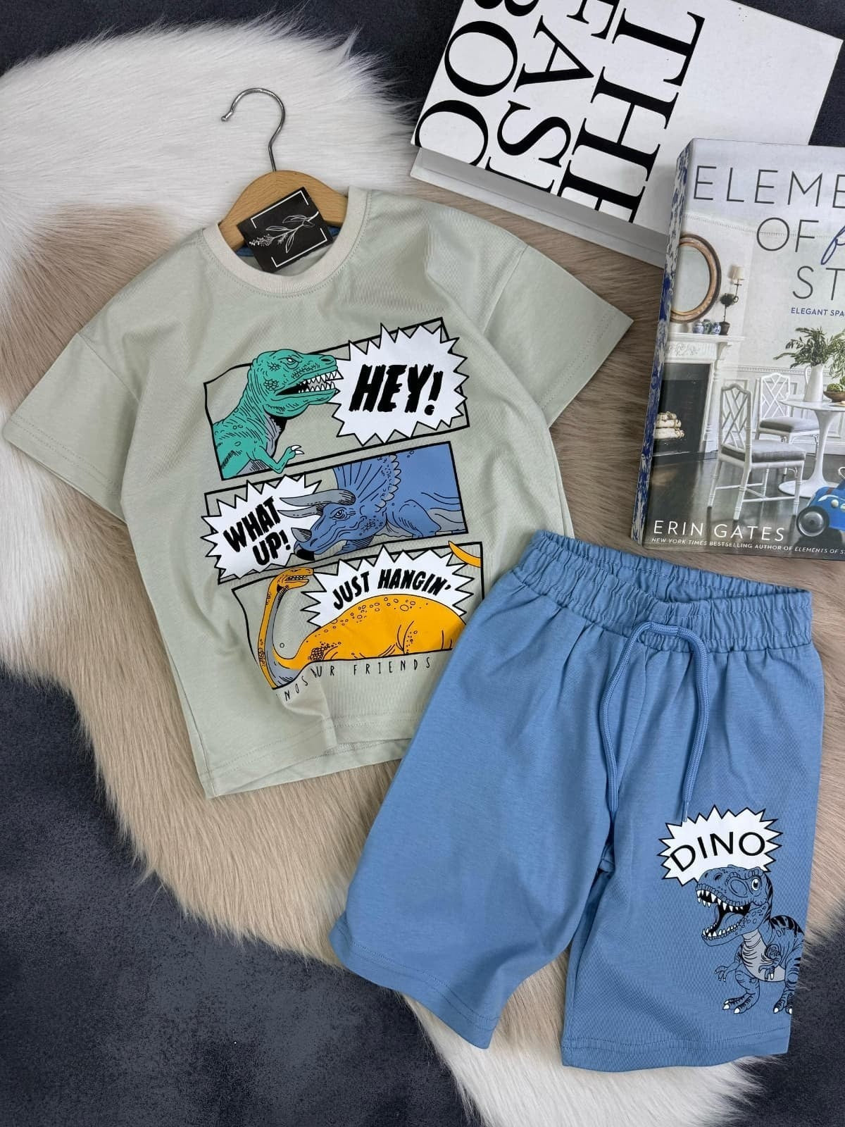The Nile Luxuries light green t-shirt and blue shorts set with dinosaur graphics and text. T-shirt has three dinosaurs with speech bubbles.