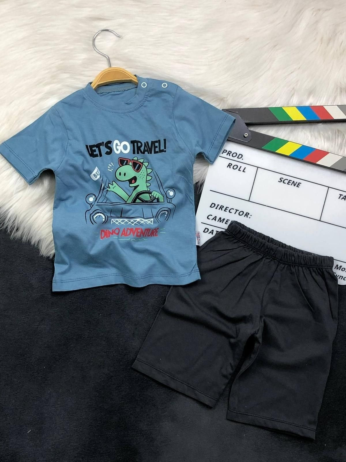 The Nile Luxuries toddler boys blue dinosaur graphic t-shirt and black shorts set with shoulder snap buttons.