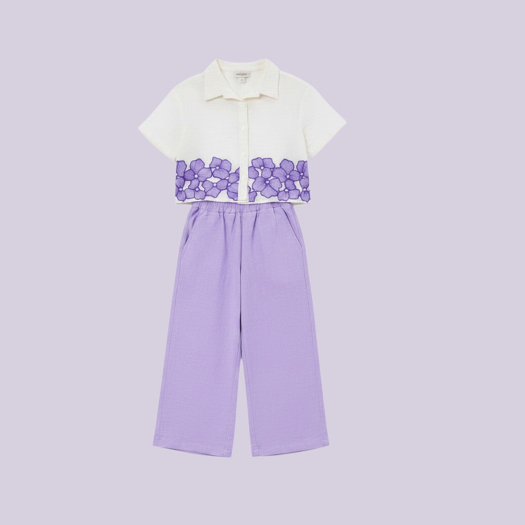 The Nile Luxuries white cropped shirt with purple floral embroidery and lavender wide-leg pants set.