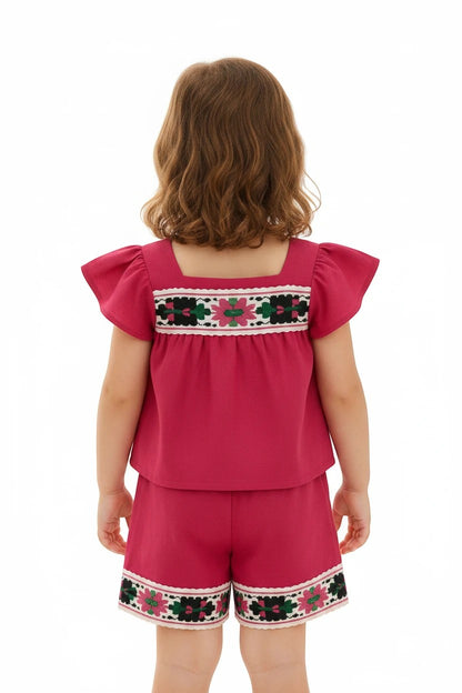 The Nile Luxuries toddler girl fuchsia flutter-sleeve top and shorts set with folk-inspired floral embroidery and lace.