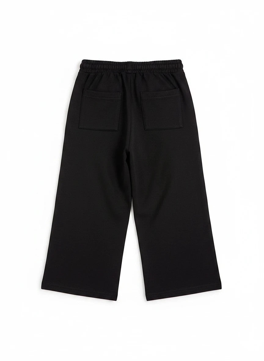 The Nile Luxuries girls black culotte pants featuring an elasticated waistband and two back patch pockets.