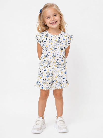 A young girl wearing The Nile Luxuries white ruffle lounge set with a cute bunny print, flutter sleeves, and shorts.