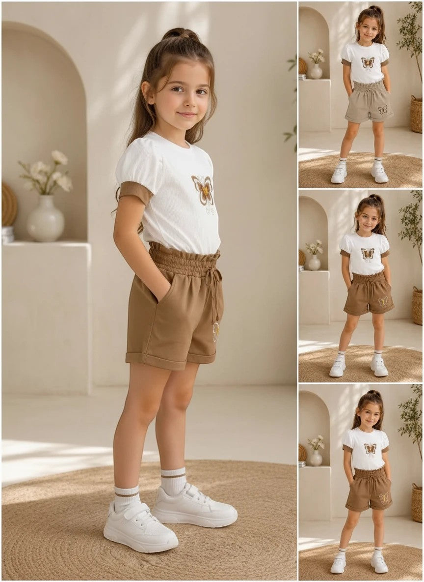 The Nile Luxuries girls white puff-sleeve butterfly t-shirt and brown paper-bag waist shorts set with white sneakers.