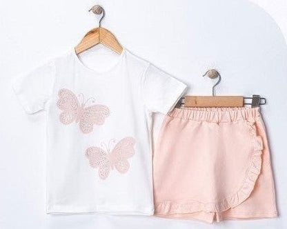 The Nile Luxuries white cotton t-shirt with two pink butterfly appliques and a pastel pink ruffled skirt with elastic waistband.