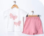 The Nile Luxuries white cotton t-shirt with pink glitter butterflies and pink ruffled skirt with elastic waist.