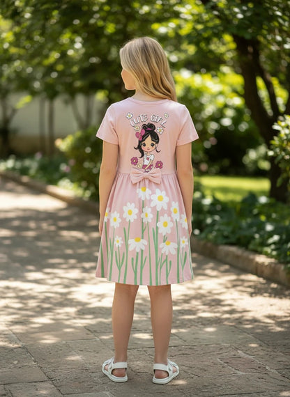 The Nile Luxuries pink casual summer dress with daisy print, Cute Girl graphic, and waist bow worn by a young girl.