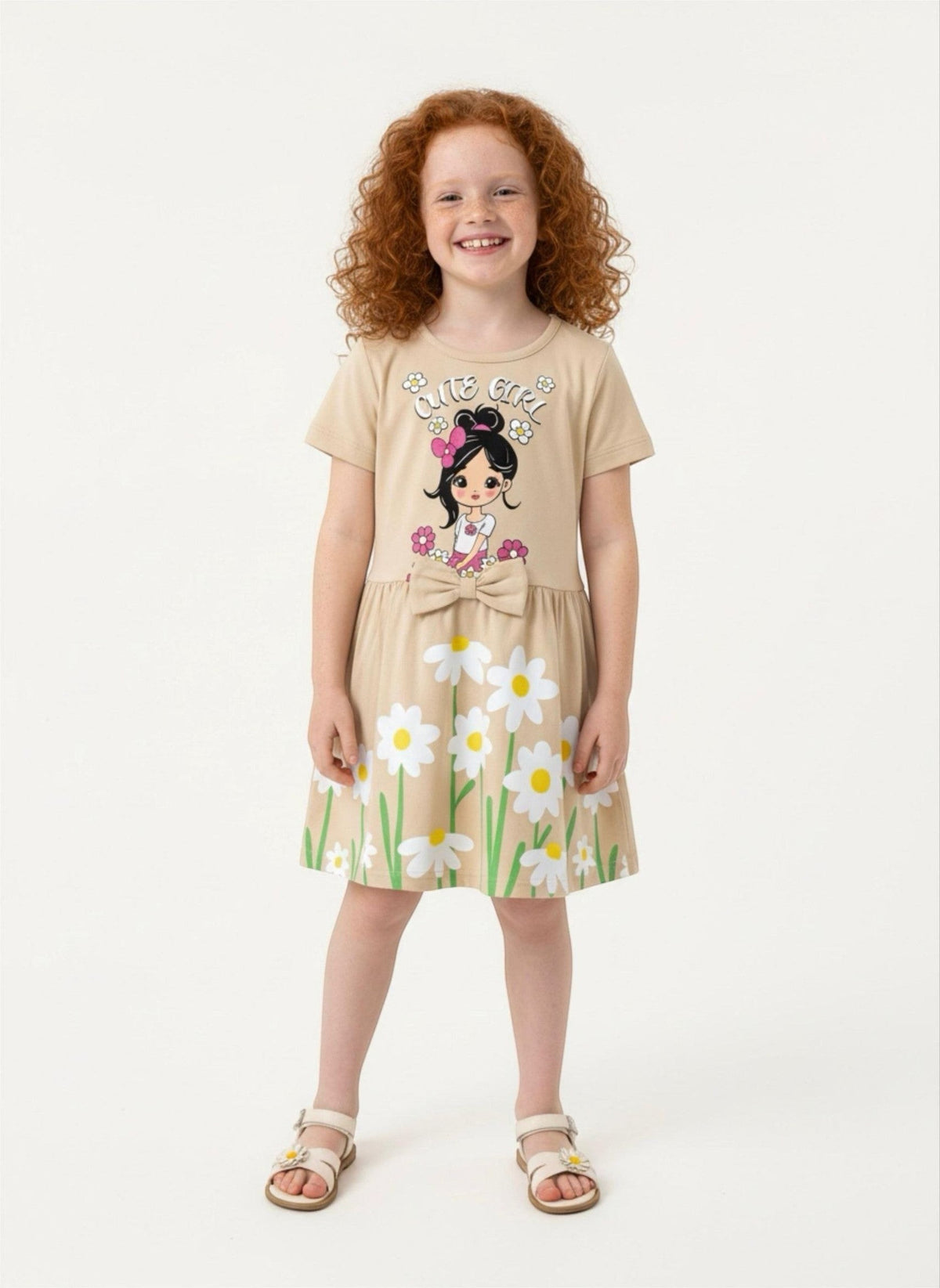 A girl wearing a beige The Nile Luxuries casual summer dress with a daisy print, graphic bodice, and waist bow.