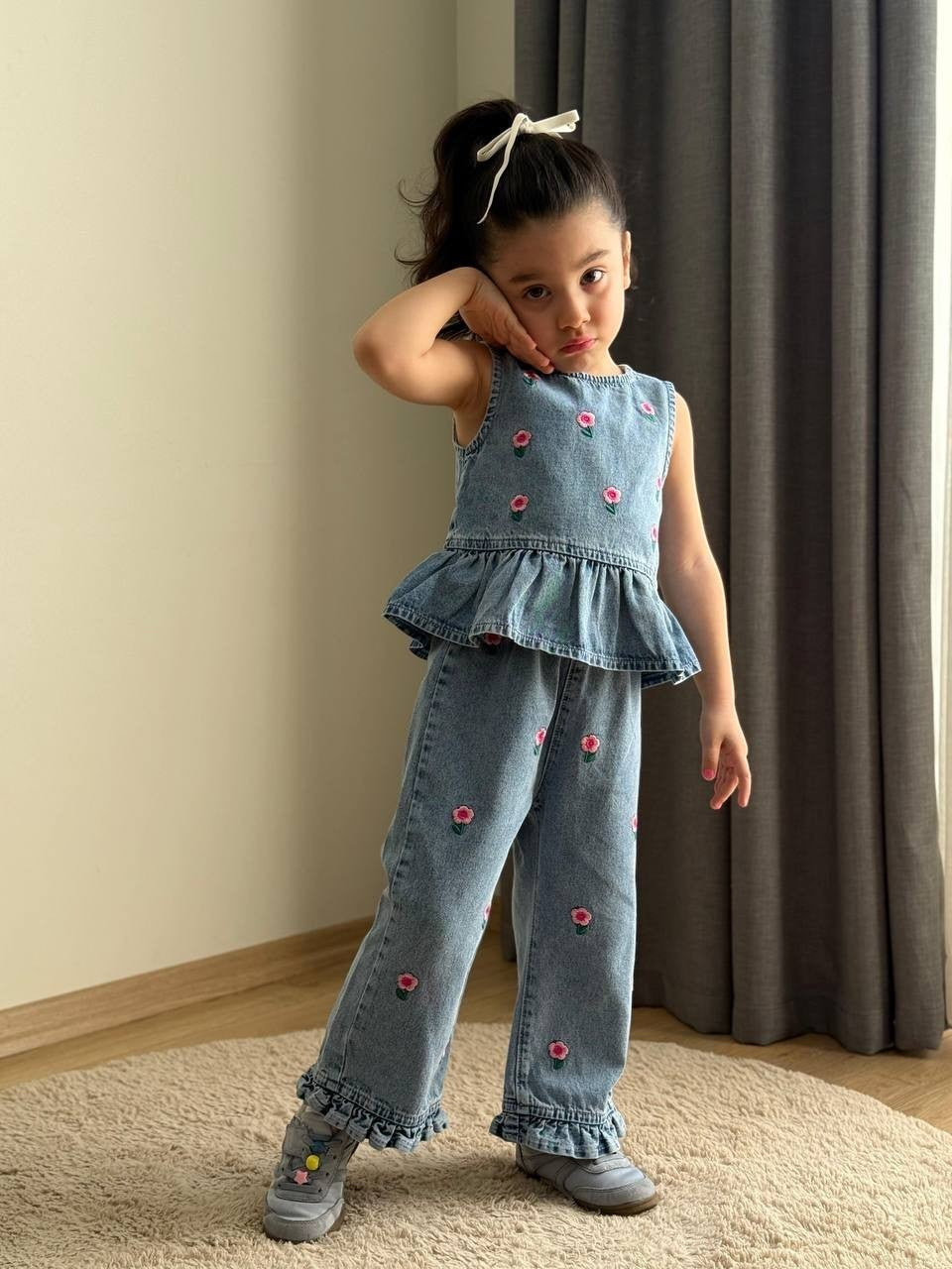 The Nile Luxuries girls blue denim peplum top and wide-leg trouser set with pink floral embroidery and ruffled hems.