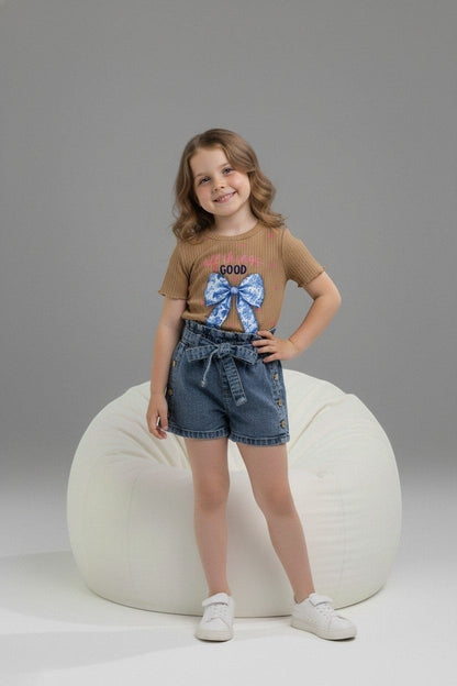 Girl wearing The Nile Luxuries ribbed brown graphic top with blue bow and denim paper-bag waist shorts with tie belt.