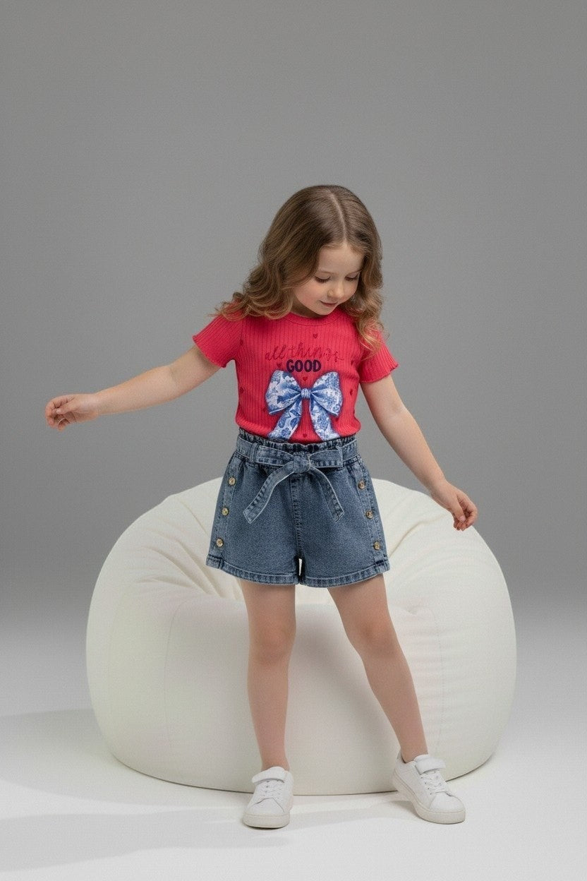 Girl wearing The Nile Luxuries red ribbed top with bow graphic and denim paper-bag waist shorts with side buttons.