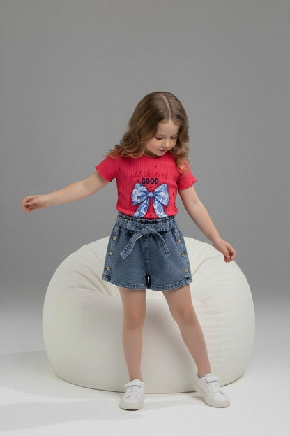 Girl wearing The Nile Luxuries red ribbed top with bow graphic and denim paper-bag waist shorts with side buttons.