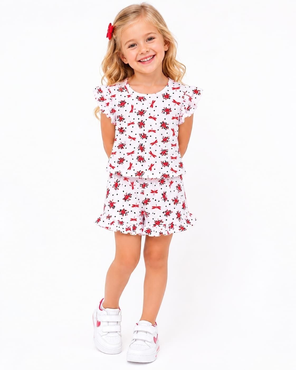 The Nile Luxuries girls' white lounge set with red dragonfly print, flutter sleeves, and ruffled shorts on a girl.