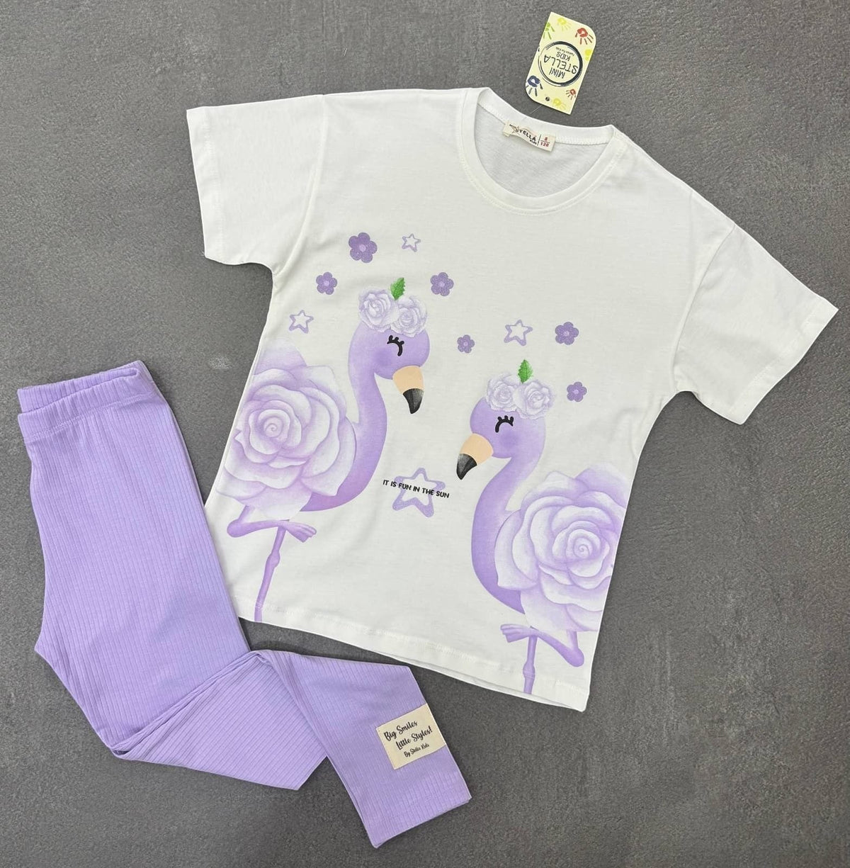 The Nile Luxuries girls two-piece set with a white graphic t-shirt featuring purple flamingos and matching ribbed leggings
