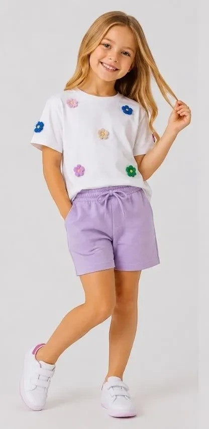 The Nile Luxuries girls white cotton t-shirt with floral appliques and lavender jersey shorts with drawstring.