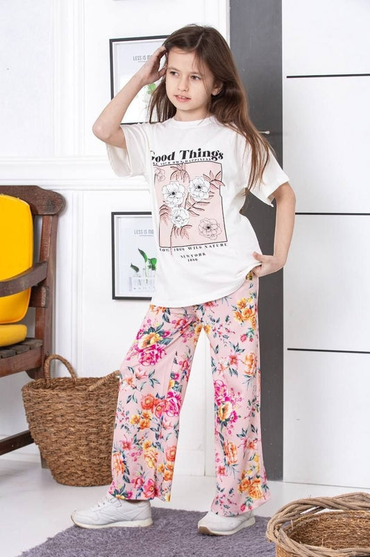 The Nile Luxuries girls lounge set with white graphic t-shirt and pink floral wide-leg pants worn by a young girl.