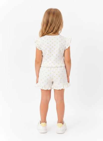 The Nile Luxuries girls white lounge set with yellow floral print, flutter sleeves, and ruffled hem shorts, back view.