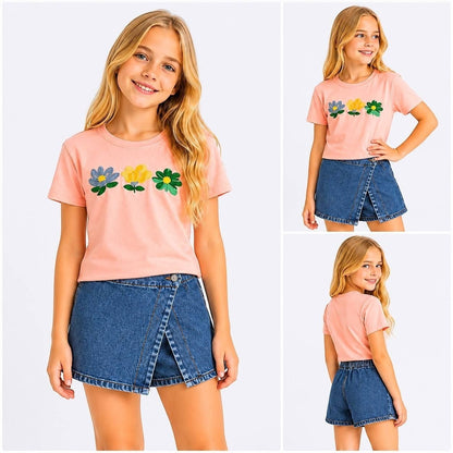 Girl wearing The Nile Luxuries pink floral embroidered t-shirt and denim wrap-front skort set on white background.