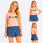 Girl wearing The Nile Luxuries pink floral embroidered t-shirt and denim wrap-front skort set on white background.