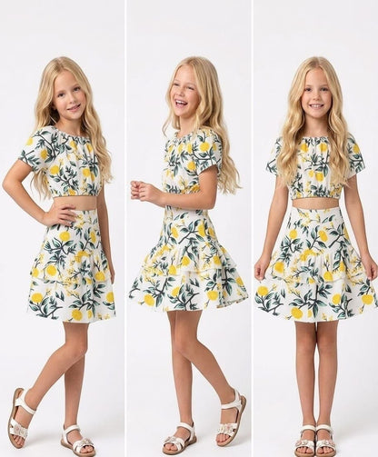 The Nile Luxuries girls two-piece set featuring a white crop top and tiered skirt with a yellow floral lemon print.