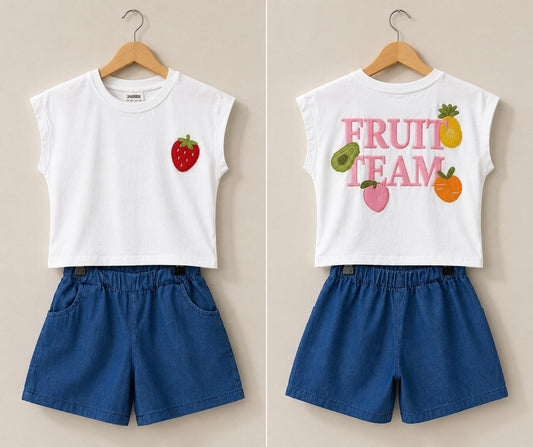 The Nile Luxuries Girls white sleeveless cotton top with embroidered strawberry and "Fruit Team" graphic, paired with blue denim shorts.