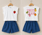 The Nile Luxuries Girls white sleeveless cotton top with embroidered strawberry and "Fruit Team" graphic, paired with blue denim shorts.