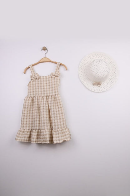 The Nile Luxuries girls' beige gingham dress with bow straps and ruffle hem, paired with a matching hat.