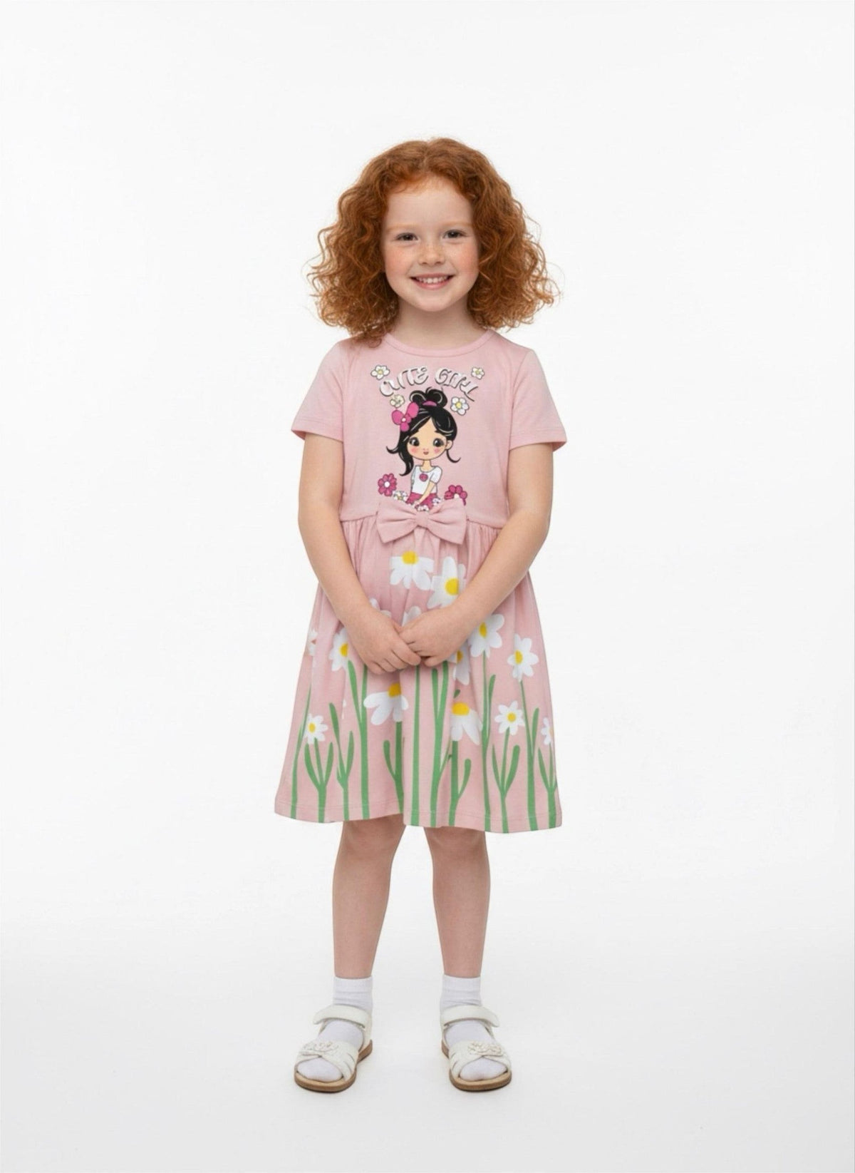 A girl wearing a pink The Nile Luxuries casual summer dress with a daisy print, Cute Girl graphic, and waist bow.