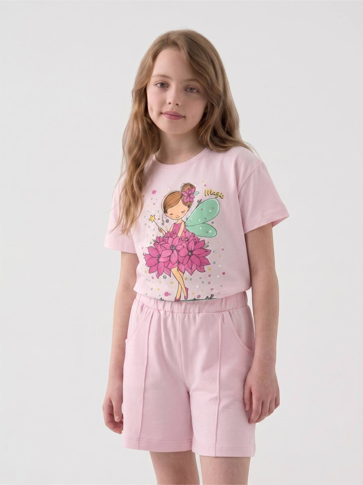 Young girl wearing a light pink The Nile Luxuries graphic t-shirt and matching shorts with a fairy print design.