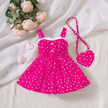 The Nile Luxuries girls' hot pink heart print sundress with white lace trim and matching purse.