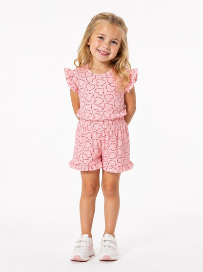 The Nile Luxuries girls pink heart print lounge set with flutter sleeves and ruffled shorts on a smiling young girl