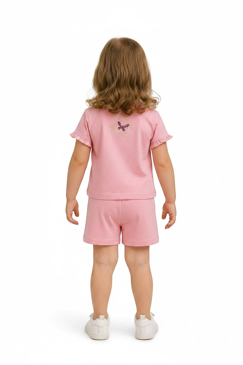The Nile Luxuries girls pink short sleeve t-shirt and shorts set with butterfly detail on back, worn by a young girl.