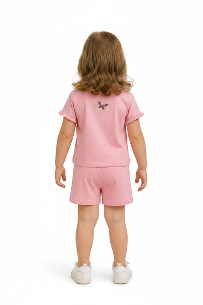 The Nile Luxuries girls pink short sleeve t-shirt and shorts set with butterfly detail on back, worn by a young girl.