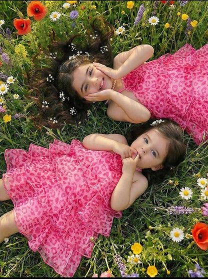 The Nile Luxuries girls' pink tiered ruffle halter neck dress with floral print and fabric flower accent.