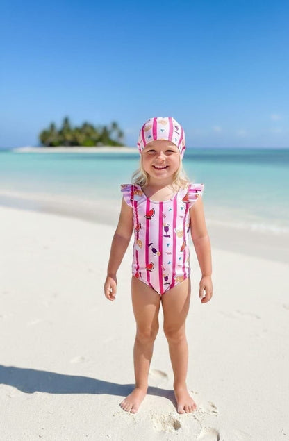 The Nile Luxuries girls pink striped swimsuit with ruffle sleeves and matching bonnet featuring a fruit and drink pattern.