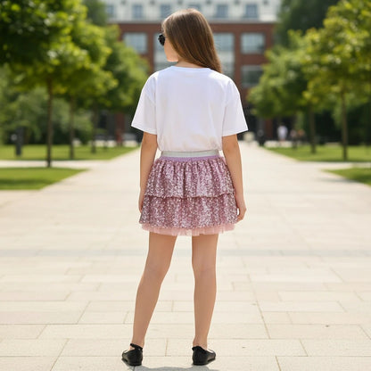 The Nile Luxuries girls' outfit featuring a white t-shirt and a pink tiered sequin skirt with a metallic waistband.