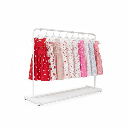The Nile Luxuries sleeveless A-line dresses for girls in various vibrant prints and colors on a white clothing rack.