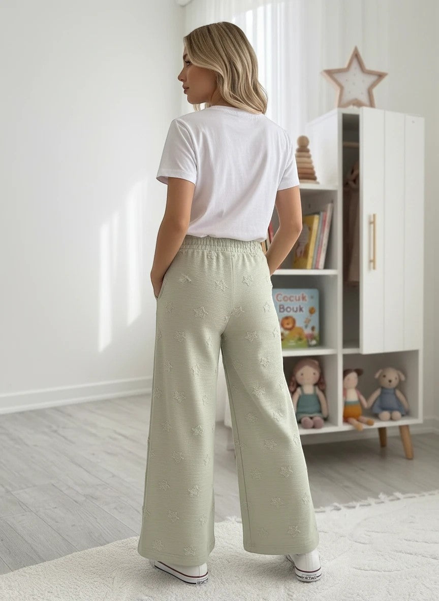 The Nile Luxuries girls' set with white t-shirt and sage green wide-leg pants featuring textured star patterns.
