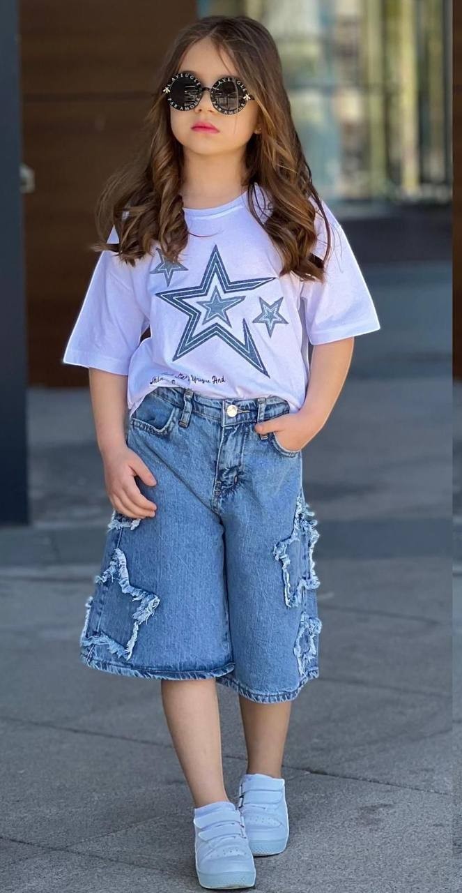 The Nile Luxuries Girls white t-shirt with star print and distressed denim shorts with star cutouts.