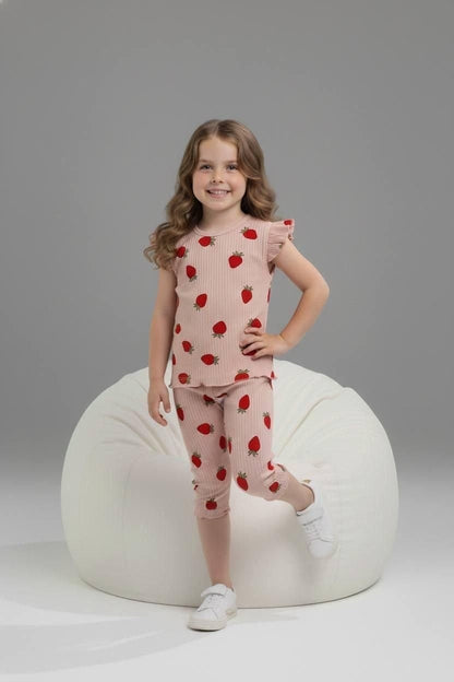 Young girl wearing The Nile Luxuries pink ribbed strawberry print lounge set with flutter sleeves and cropped leggings.