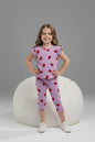 Young girl wearing The Nile Luxuries lavender ribbed strawberry print lounge set with flutter sleeves and leggings.