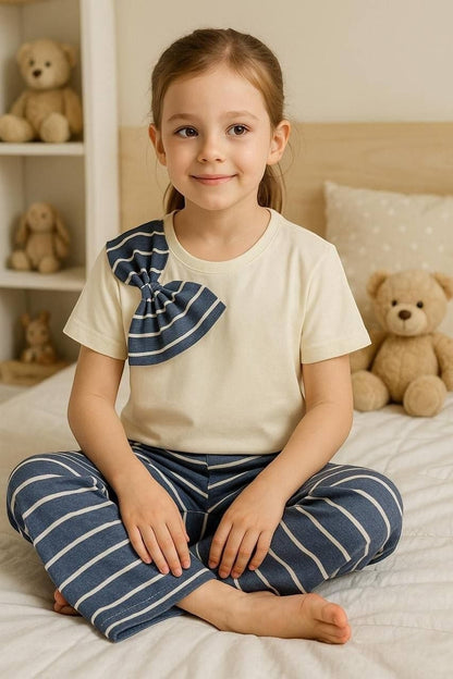 The Nile Luxuries girls pajama set with cream crew-neck top, blue striped bow detail, and matching striped wide-leg pants.
