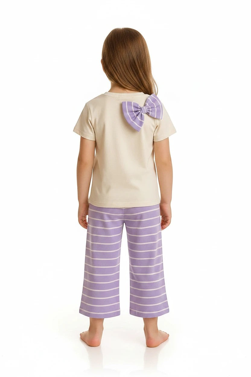 The Nile Luxuries girls pajama set with a cream top, purple bow detail, and striped wide-leg pants, back view.