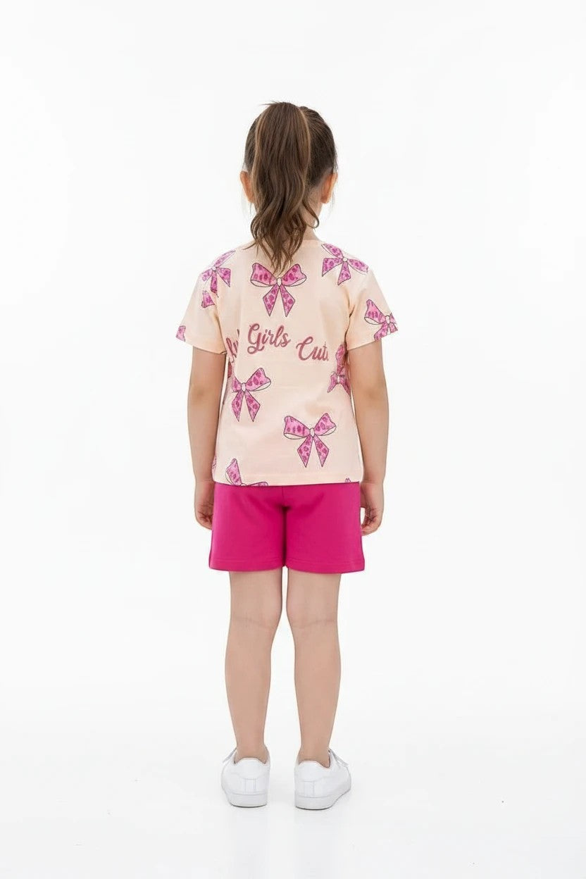 The Nile Luxuries girls' summer set with a peach bow-print t-shirt and vibrant pink shorts for casual play.