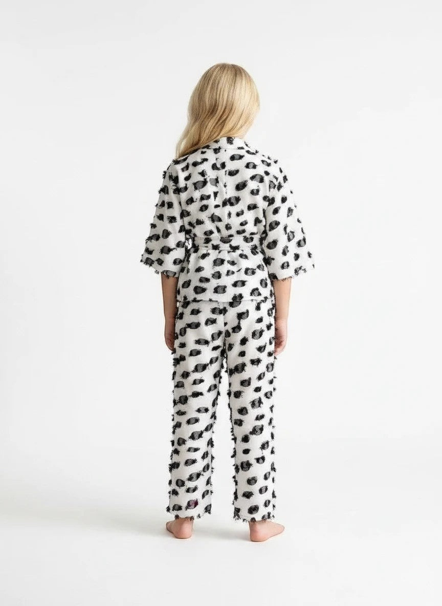 The Nile Luxuries girls two-piece lounge set in white with black textured dots, kimono top, and frayed hem details.
