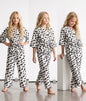 The Nile Luxuries girls two-piece lounge set in white with black textured dots, kimono top, and frayed hem details.