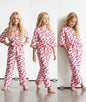 The Nile Luxuries girls two-piece lounge set in white with pink textured dots, featuring a kimono top and tie waist.