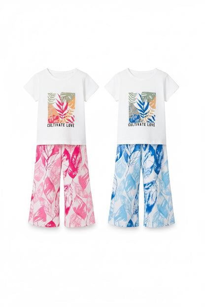 The Nile Luxuries girls' two-piece outfit with white graphic t-shirt and pink or blue tropical leaf print trousers.