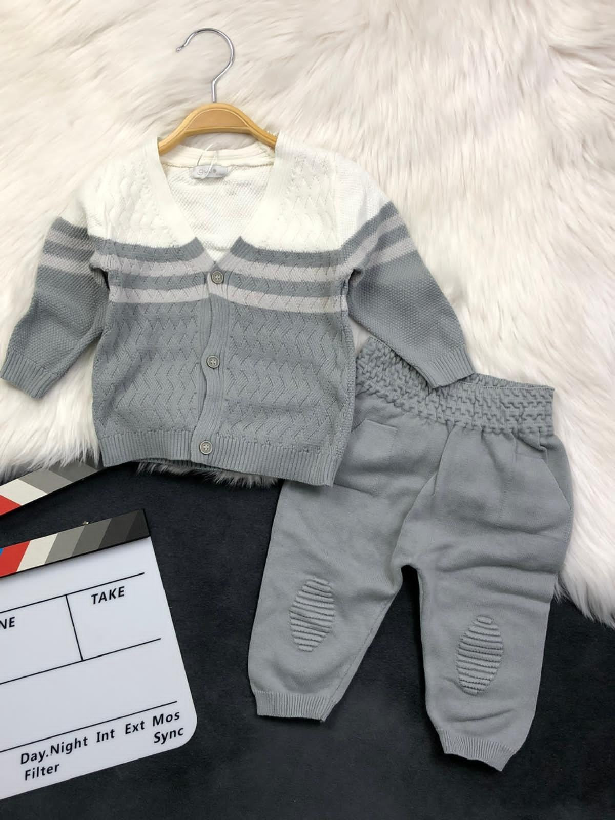 The Nile Luxuries infant knit cardigan and trousers set in white and grey with textured patterns and button closure.