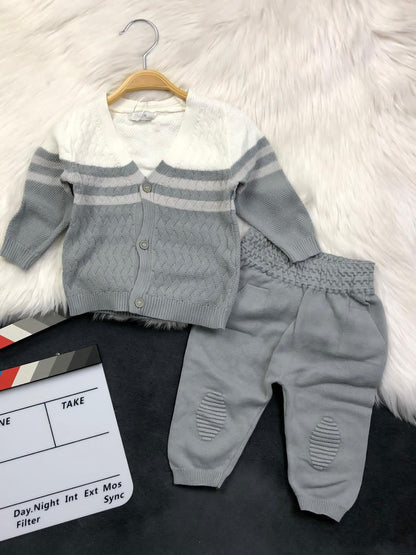 The Nile Luxuries infant knit cardigan and trousers set in white and grey with textured patterns and button closure.